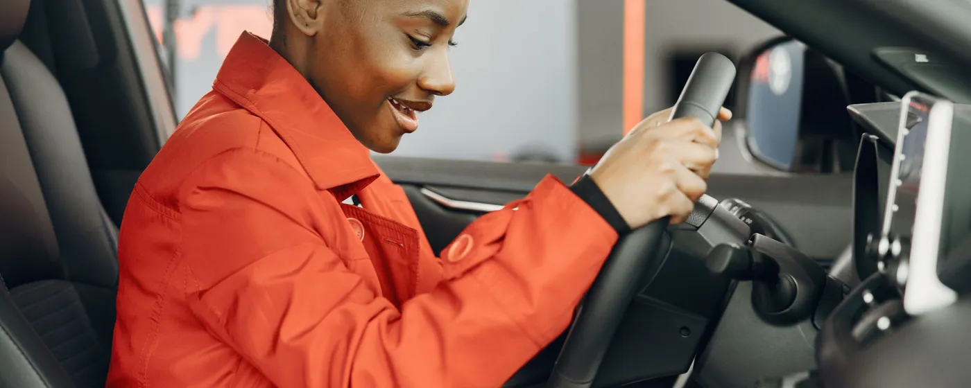 Blije leerling achter het stuur na een geslaagde rijles bij Rijles XL